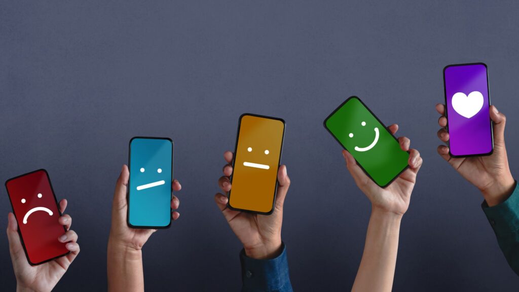 People holding their phones up with smileys to represent customer experience and satisfaction.
